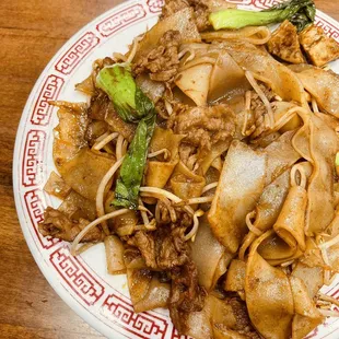 a plate of noodles and meat