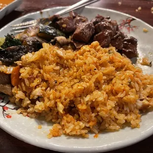 a plate of rice with meat and vegetables