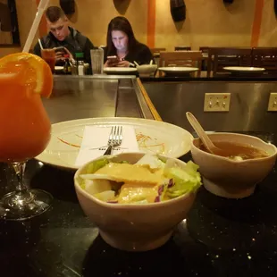 a bowl of salad and a glass of orange juice