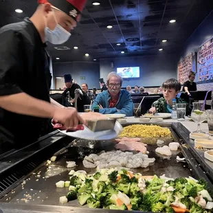 a man wearing a face mask preparing food