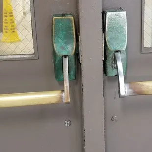 Green rust on the door handles leading to the main area of the Y from the pool