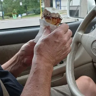 a man eating a sandwich in a car
