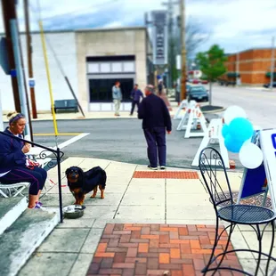 a woman and her dog on a sidewalk