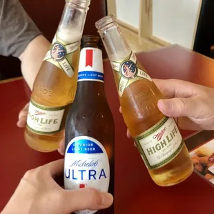 two people clinking beer bottles