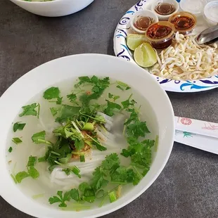  two bowls of soup and a plate of noodles