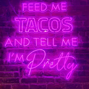 a neon sign that reads feed me tacos and tell me i'm pretty