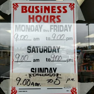 a business hours sign in a window