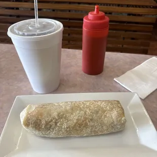 Breakfast burrito with a large drink.