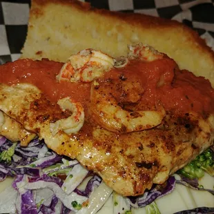 Gulf Coast Red Fish Po'Boy: Cajun dusted, served over lemon pepper slaw, topped with a smoked shrimp tomato buerre blank.