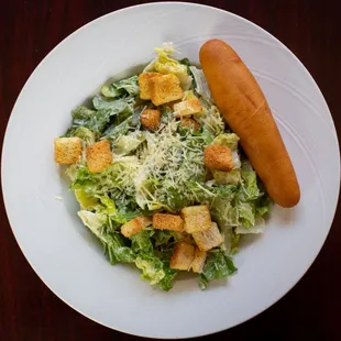 a plate of salad and a hot dog