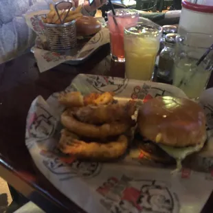 a burger and onion rings on a table