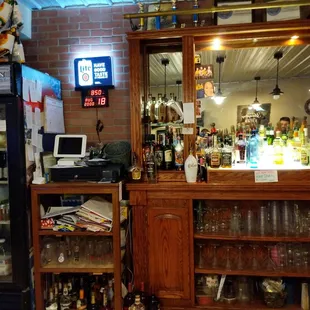 a bar with liquor bottles and a television