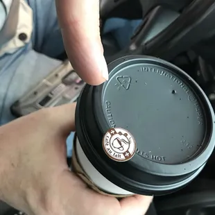 a hand holding a coffee cup
