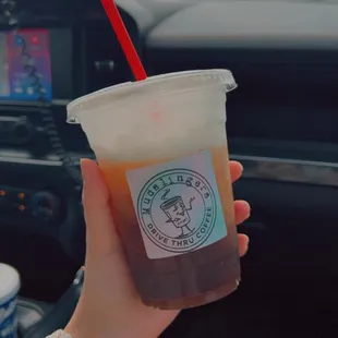 a hand holding a cup of iced coffee