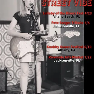 a woman playing a guitar and singing into a microphone