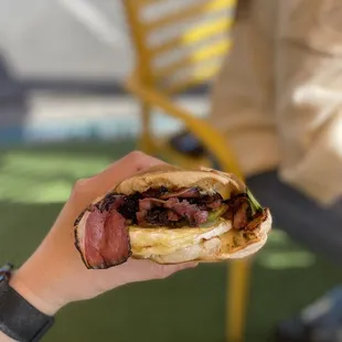 a hand holding a sandwich