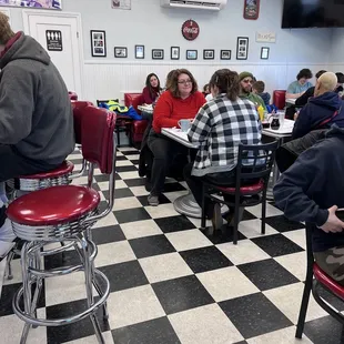 people sitting at tables in a diner