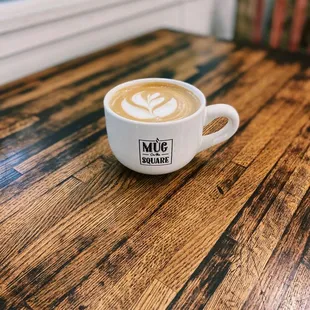 a cup of coffee on a wooden table
