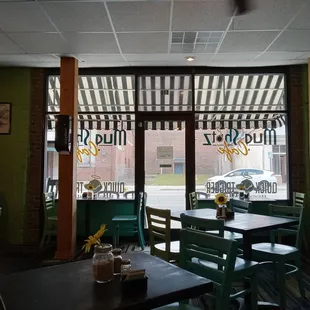 tables and chairs in front of a window