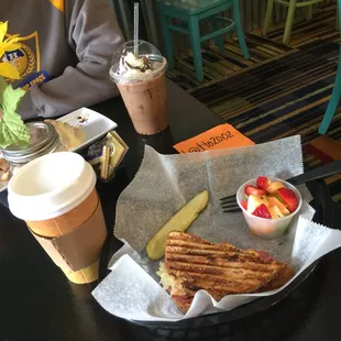 White chocolate mocha and half sandwich of Ruben, pickle, and cup of fruit