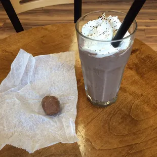 a cup of coffee and a chocolate covered donut