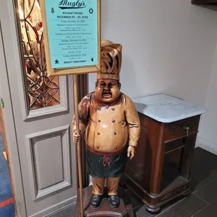 a wooden statue of a chef