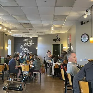 people sitting at tables in a coffee shop
