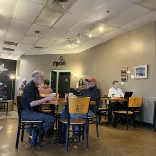 people sitting at tables in a coffee shop