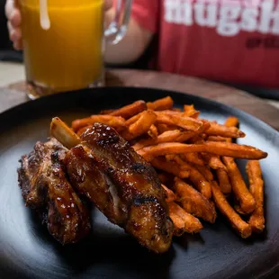a plate of ribs and sweet potato fries