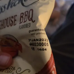 a hand holding a bag of dog food