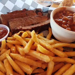 Sliced brisket, fries, and baked beans.