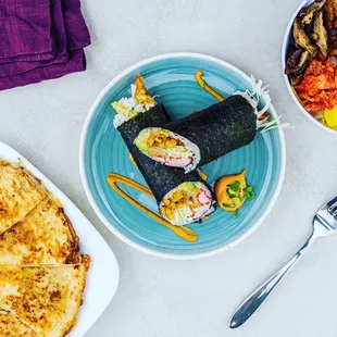 a plate of sushi and a bowl of vegetables