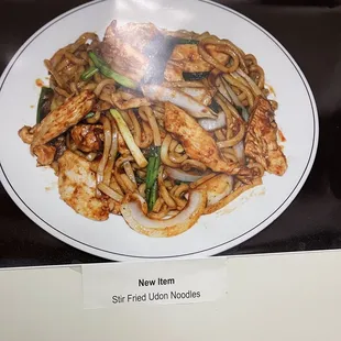 a plate of noodles and meat