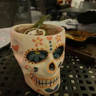 a skull mug with a drink in it