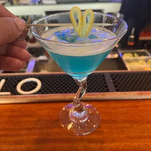 a hand holding a martini glass