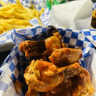 a basket of chicken wings and french fries