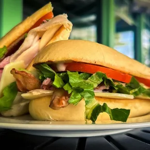 Clubhouse Sandwich | Freshly shaved smoked turkey &amp; ham, bacon, lettuce, tomato, Swiss, cheddar &amp; honey mustard on grilled Cuban roll