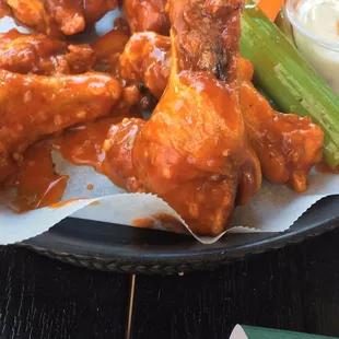 a plate of buffalo wings and celery