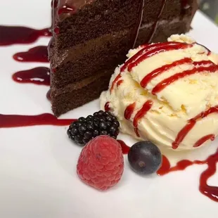 a slice of chocolate cake with ice cream and berries