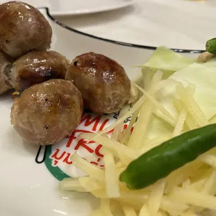 Isaan sausages served with fresh pepper, cabbage, roasted peanuts, fresh julienne ginger