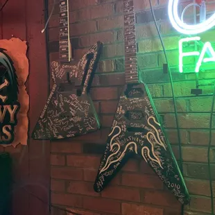 a brick wall with various neon signs