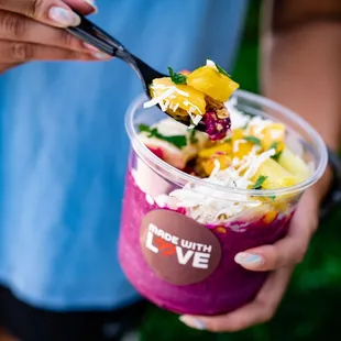 a woman holding a cup of smoothie