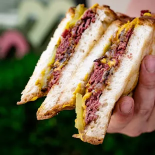 a person holding a sandwich in their hand