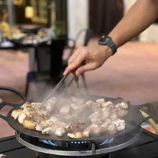 a person cooking food on a grill