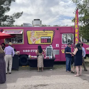 a group of people standing around a food truck