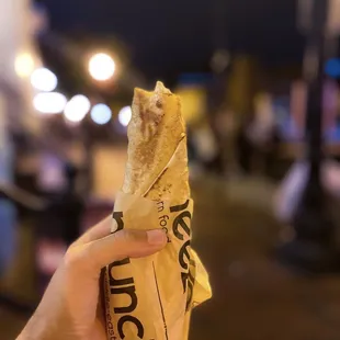 a person holding a sandwich in their hand