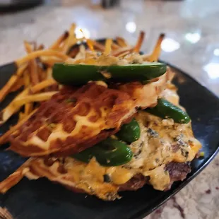 a waffle sandwich with green peppers on top