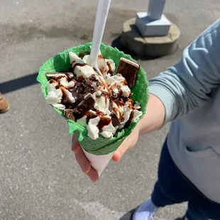 a person holding a waffle cone