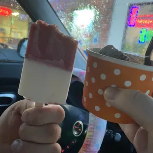 a person holding a cup of ice cream