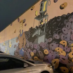a car parked in front of a mural